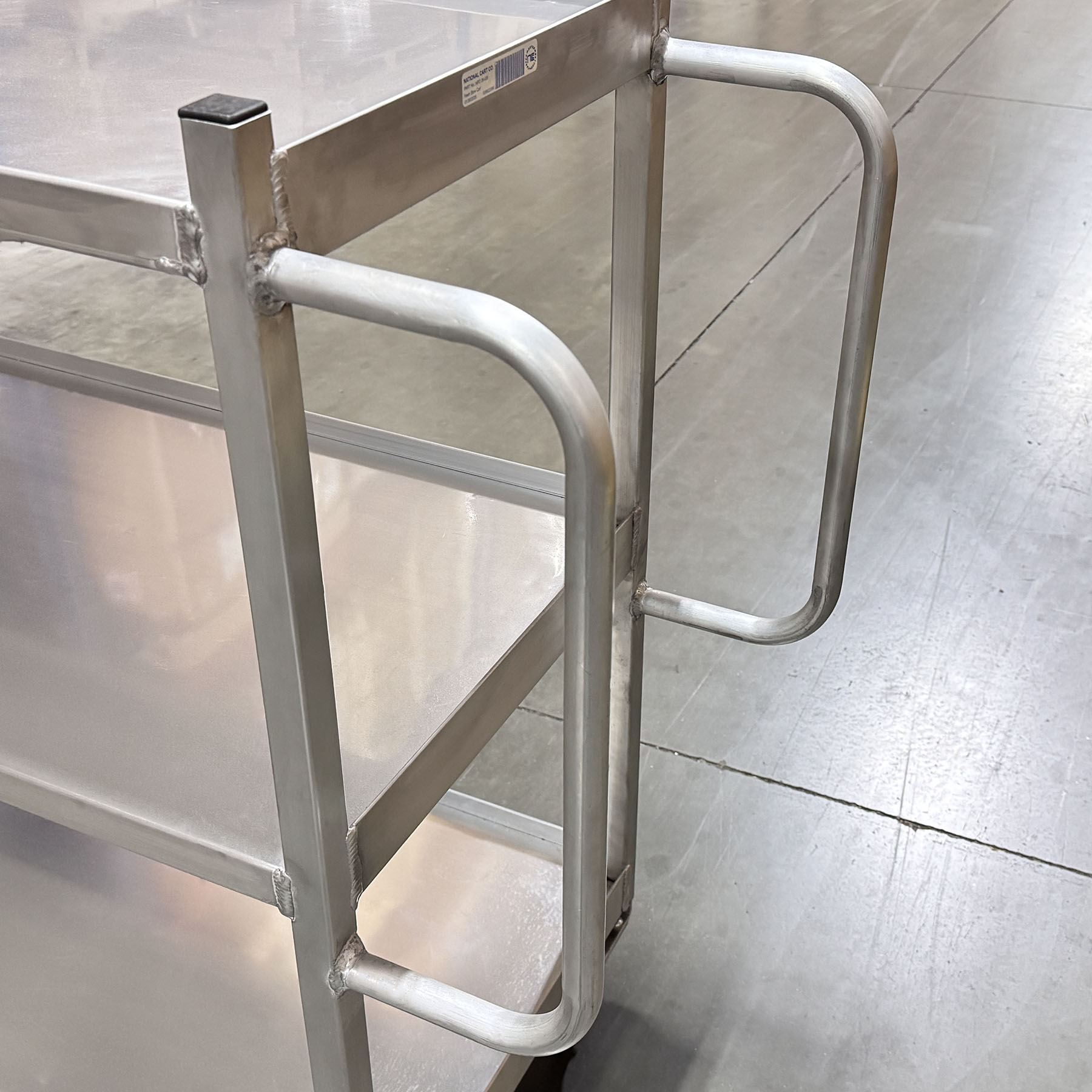 Three-tier aluminum utility cart used for grocery store stocking and backroom product movement.